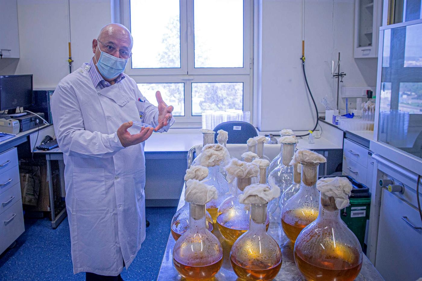 homem de bata branca, com máscara no laboratório