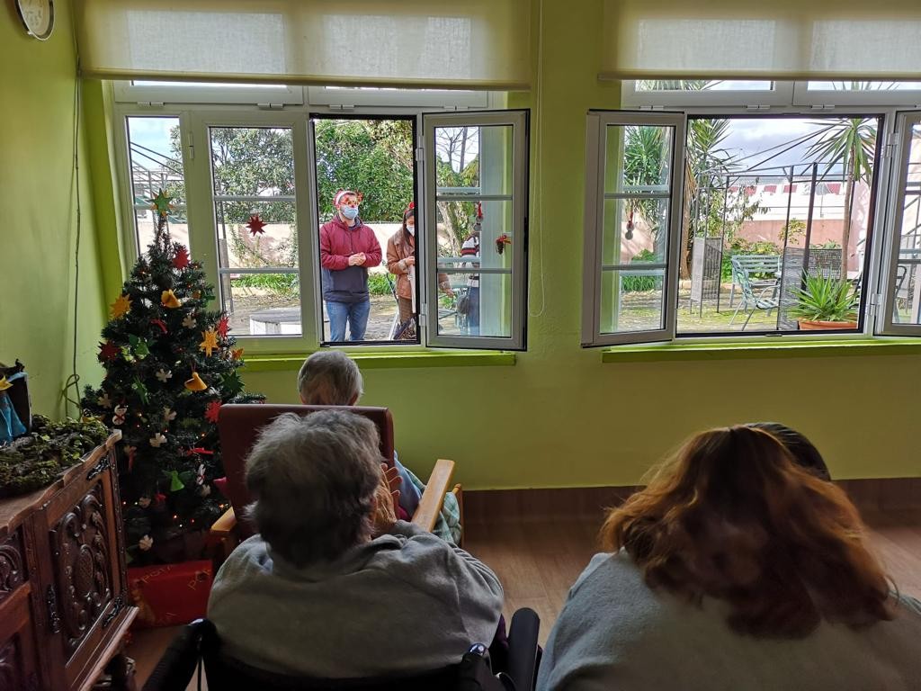 idosos assistir a uma serenata na janela feita por alunos da fmul