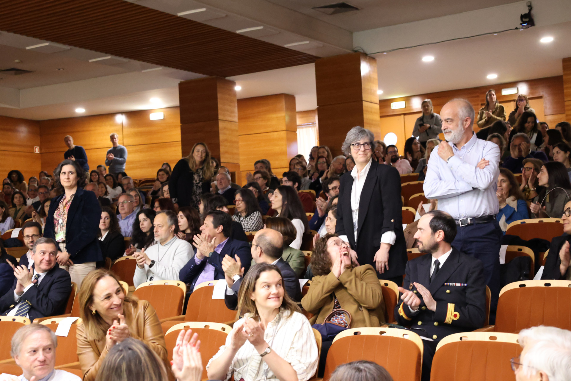 pessoas a aplaudir homenageados