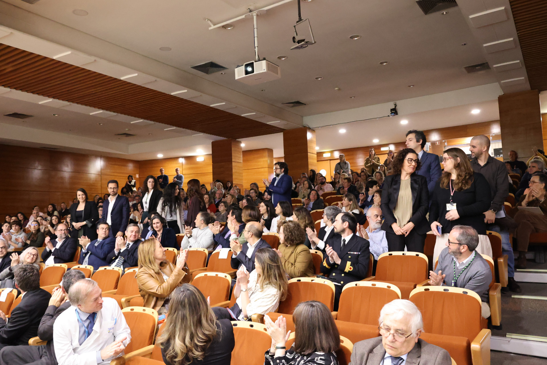 pessoas a aplaudir homenageados