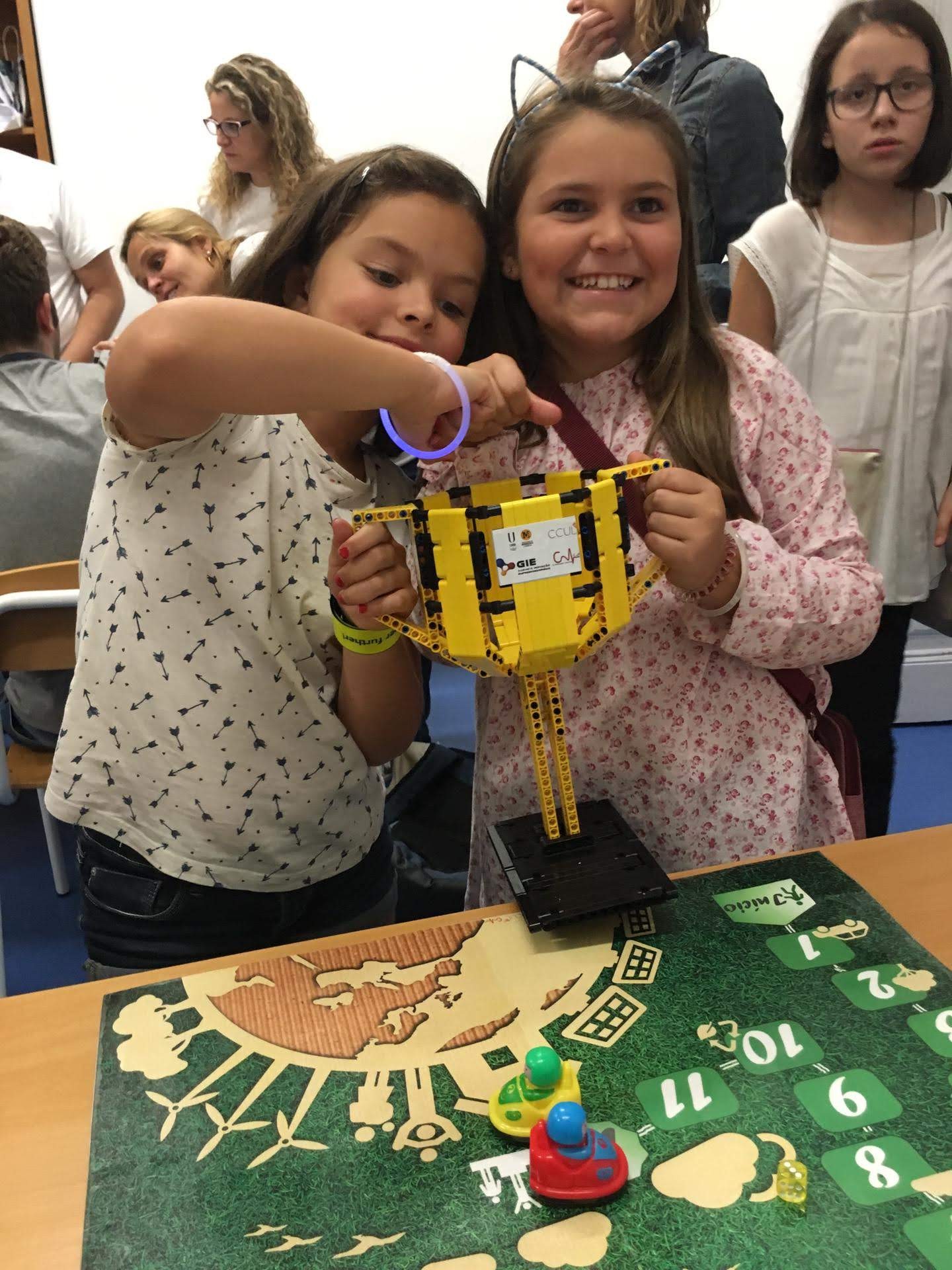 Duas meninas brincam sorridentes com os legos