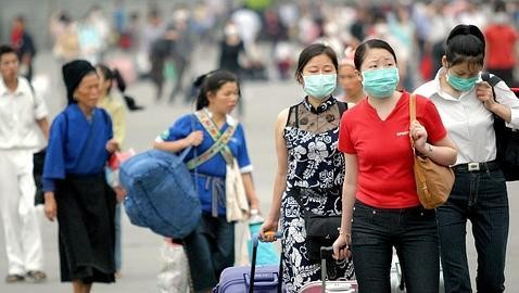 pessoas da asia a andarem de máscara pela rua