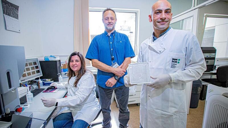 dois homens e uma mulher, cientistas, a trabalhar num laboratório