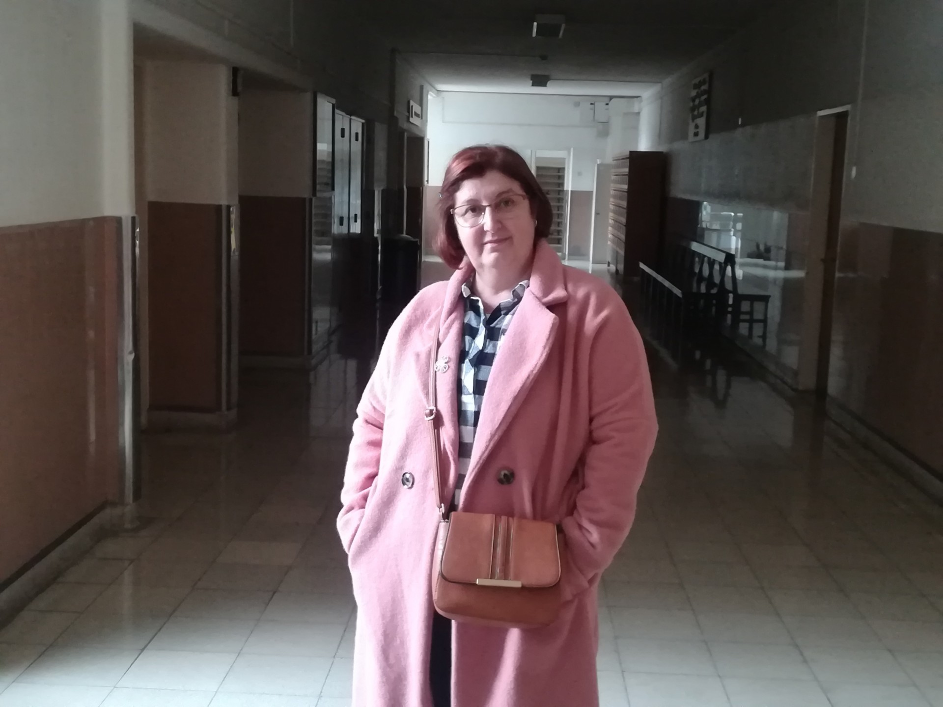 Senhora em pé com casaco rosa