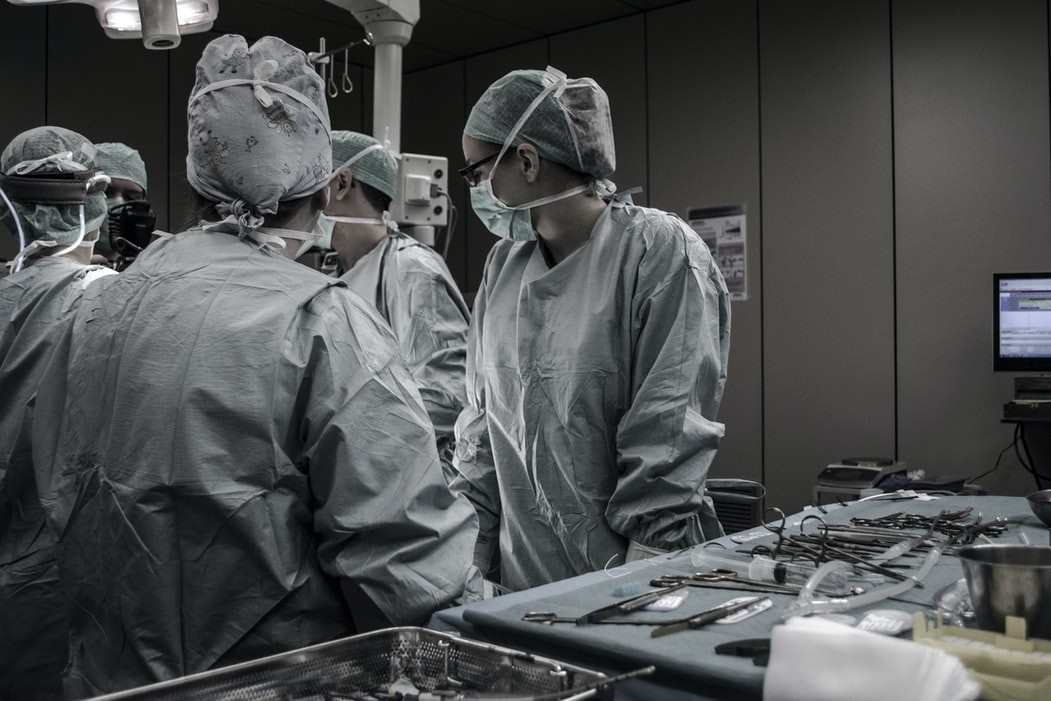 médicos em fatos cirúrgicos numa sala de operações