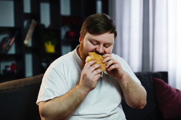 Homem obeso a comer