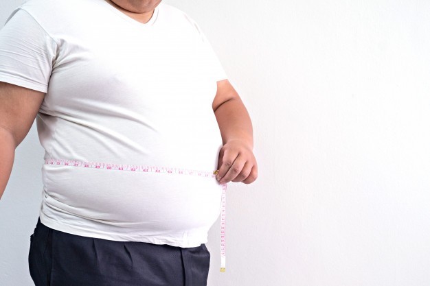 Homem obeso com fita métrica à volta da barriga