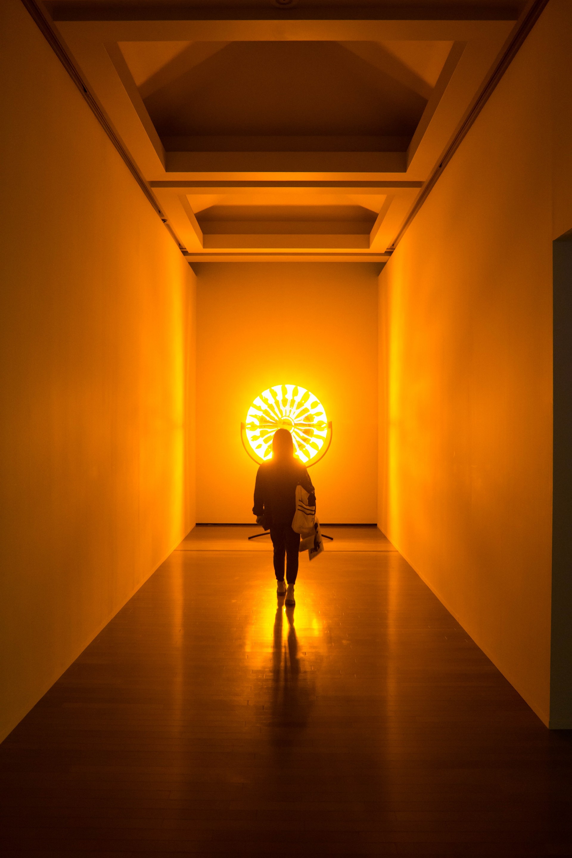 pessoa num corredor a caminhar em direção a uma luz amarela